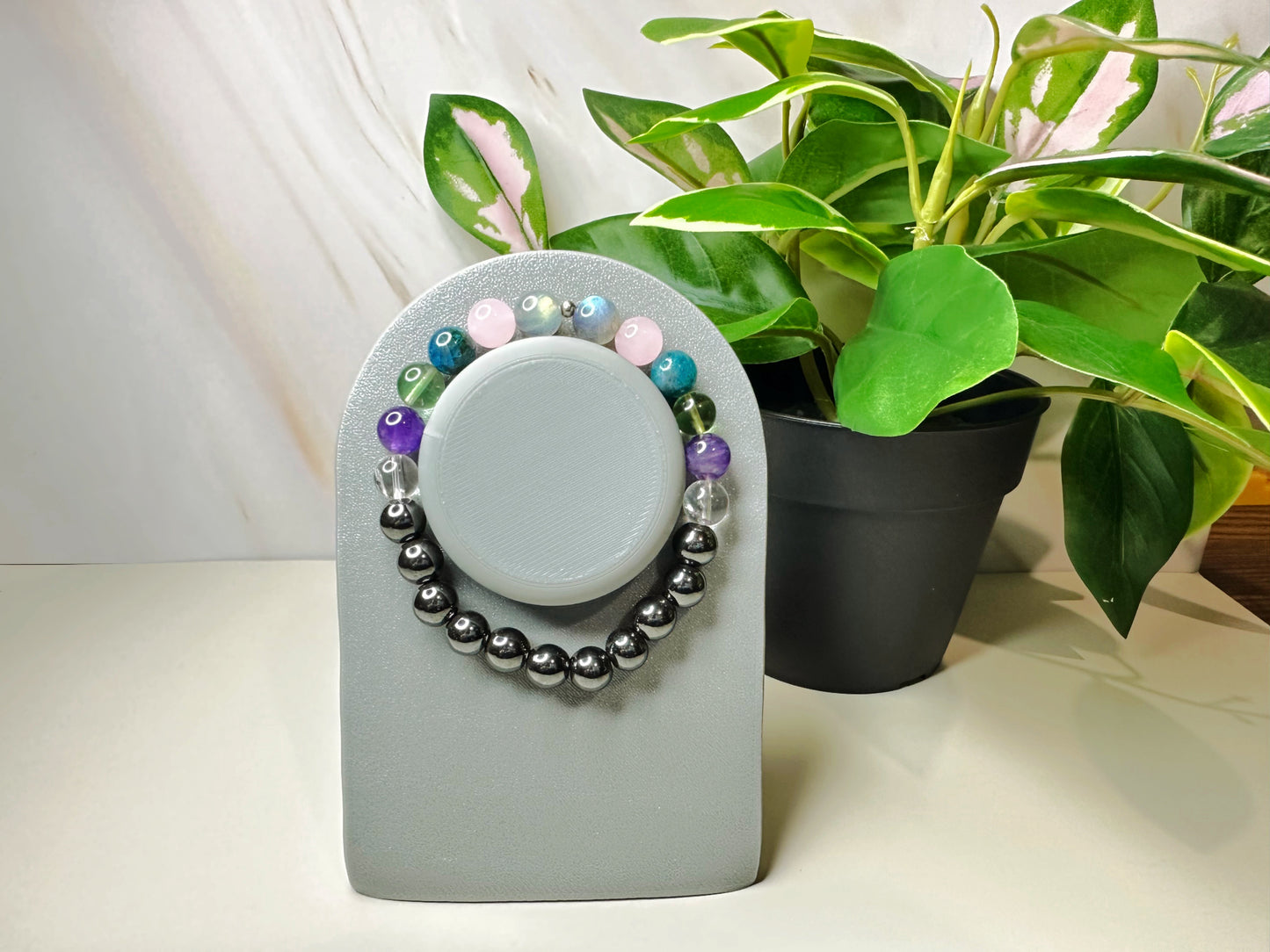 Decorative item with beads on a gray base next to a potted plant