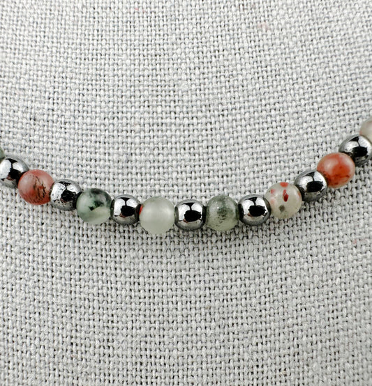 Beaded bracelet with silver and multicolored beads on a textured fabric background