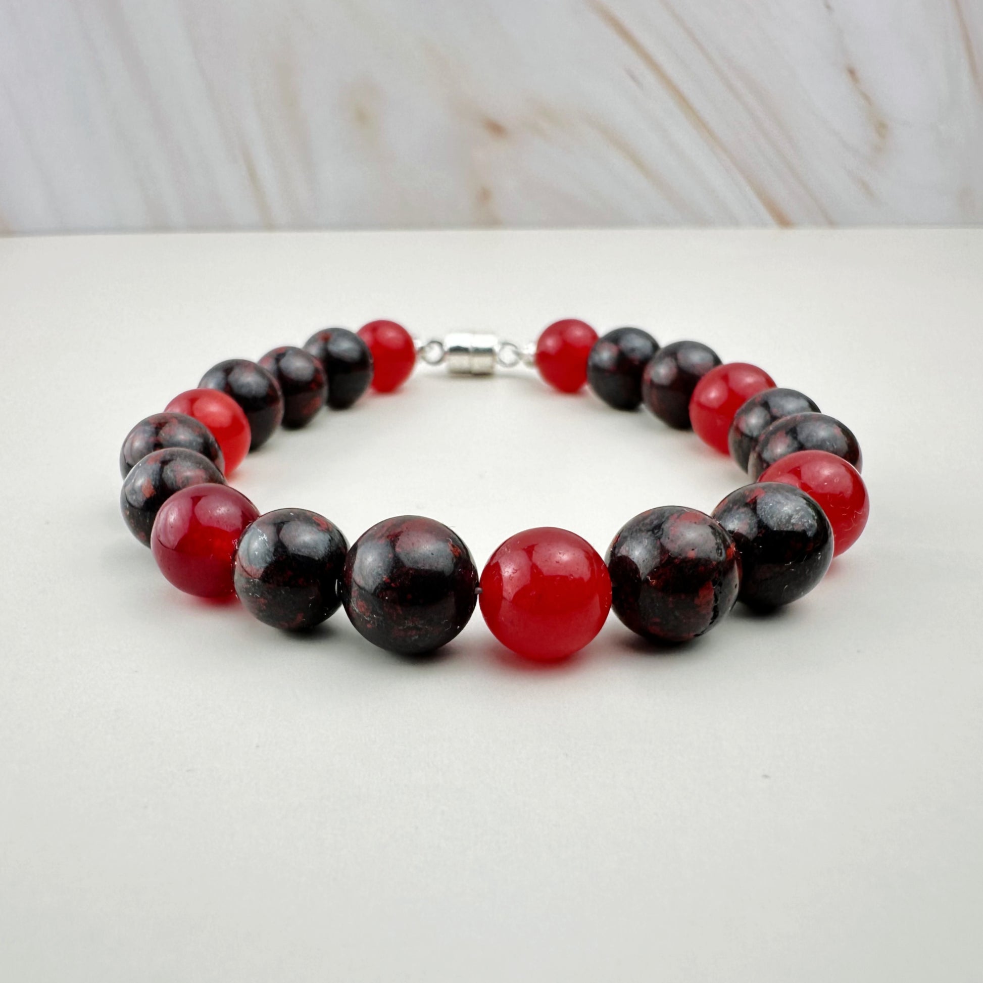 Bracelet with red and black beads on a white surface