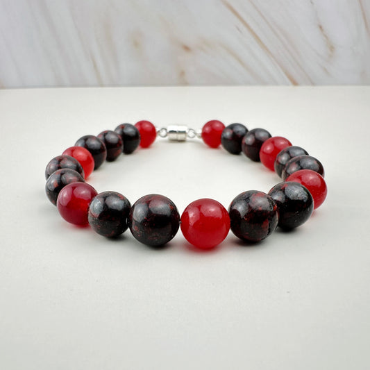 Bracelet with red and black beads on a white surface