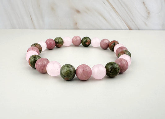 Bracelet with pink and green beads on a white surface