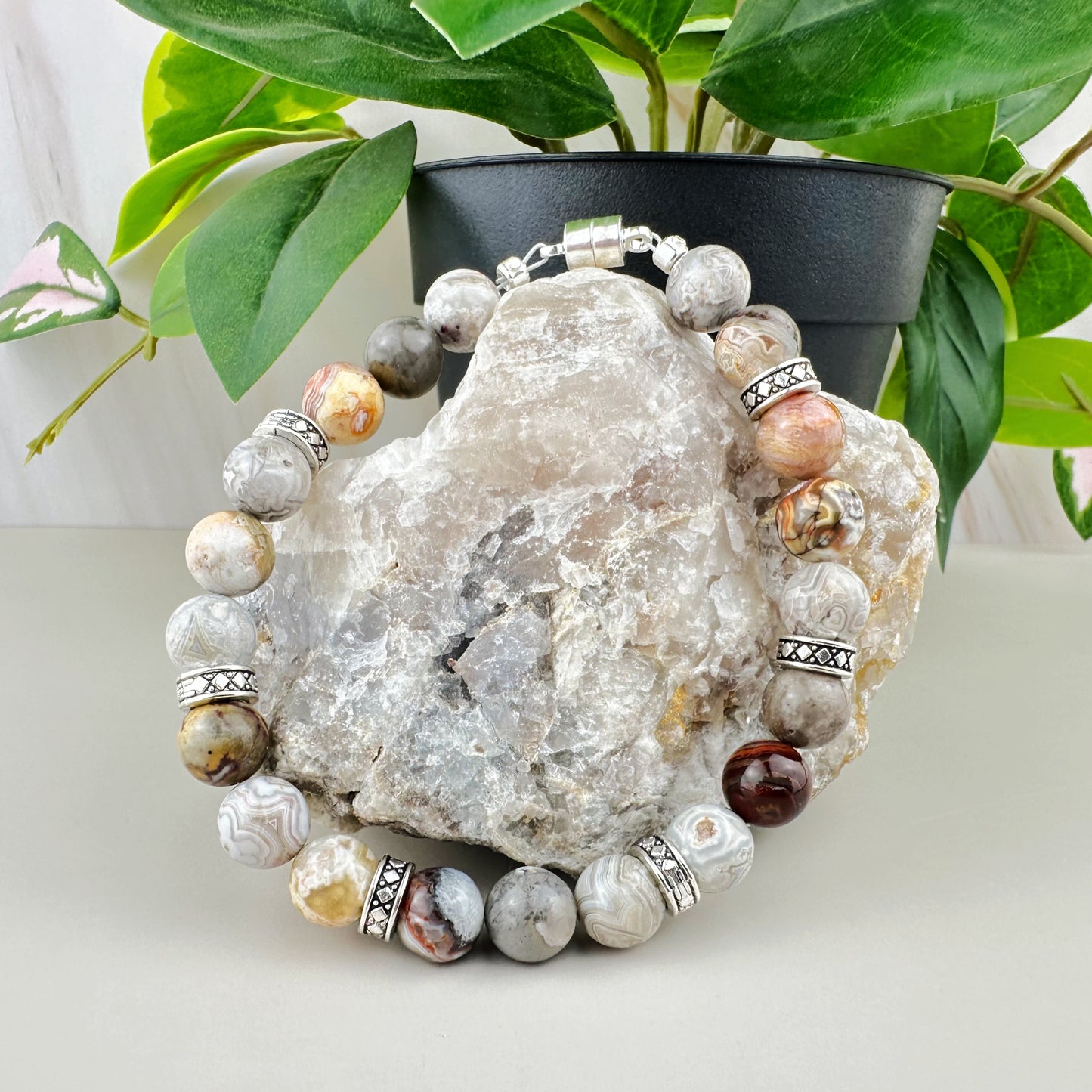 Beaded bracelet on a rock with a plant in the background
