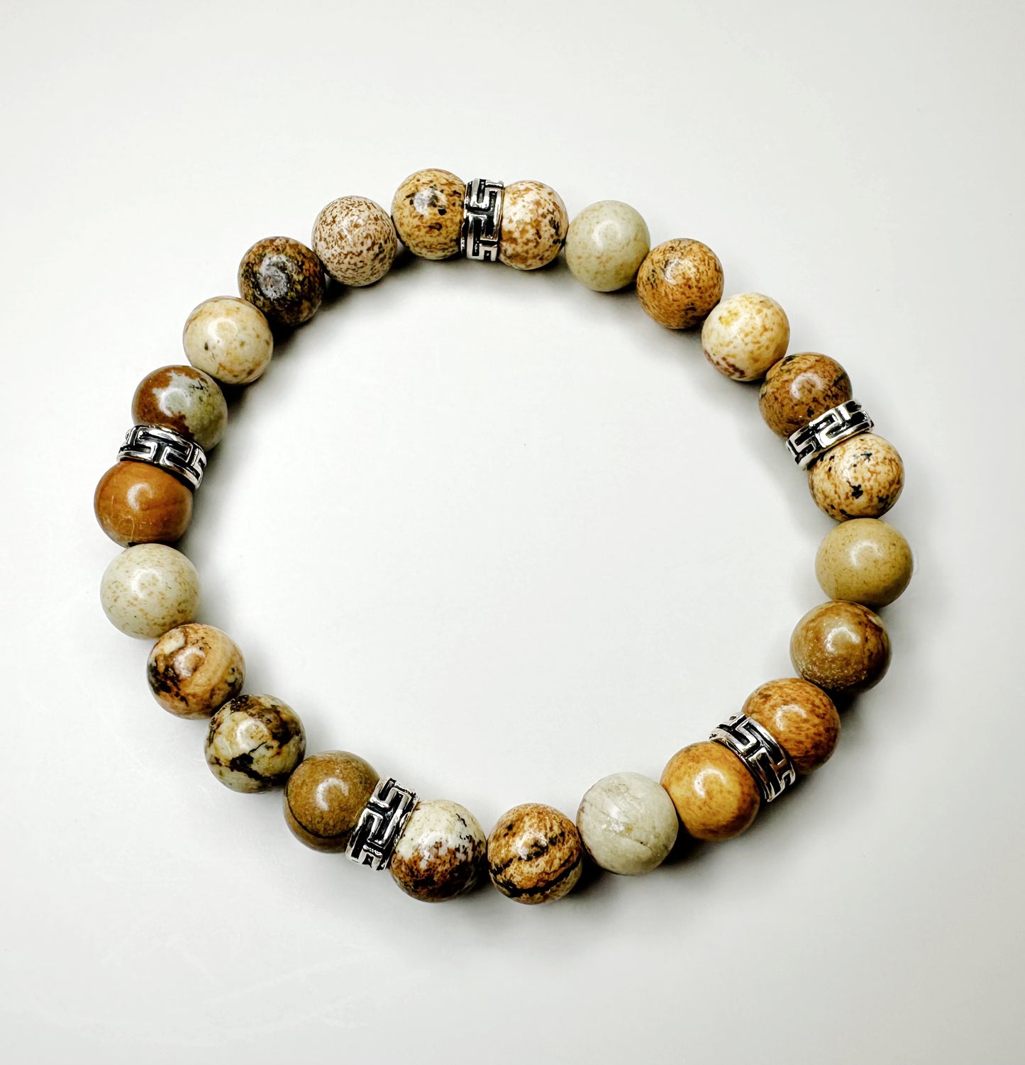 Beaded bracelet with natural stone beads and metal accents on a white background
