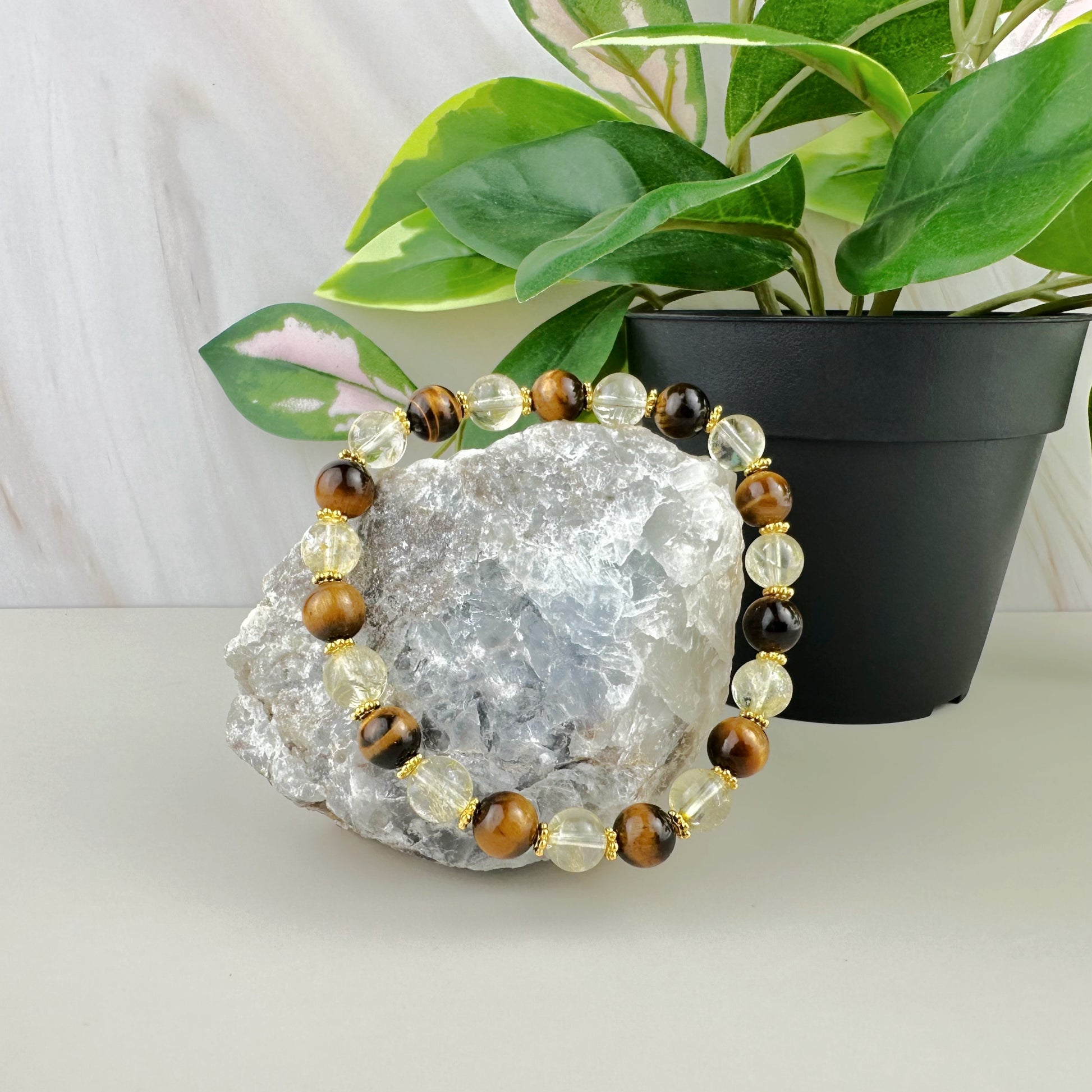 Beaded bracelet on a crystal with a plant in the background