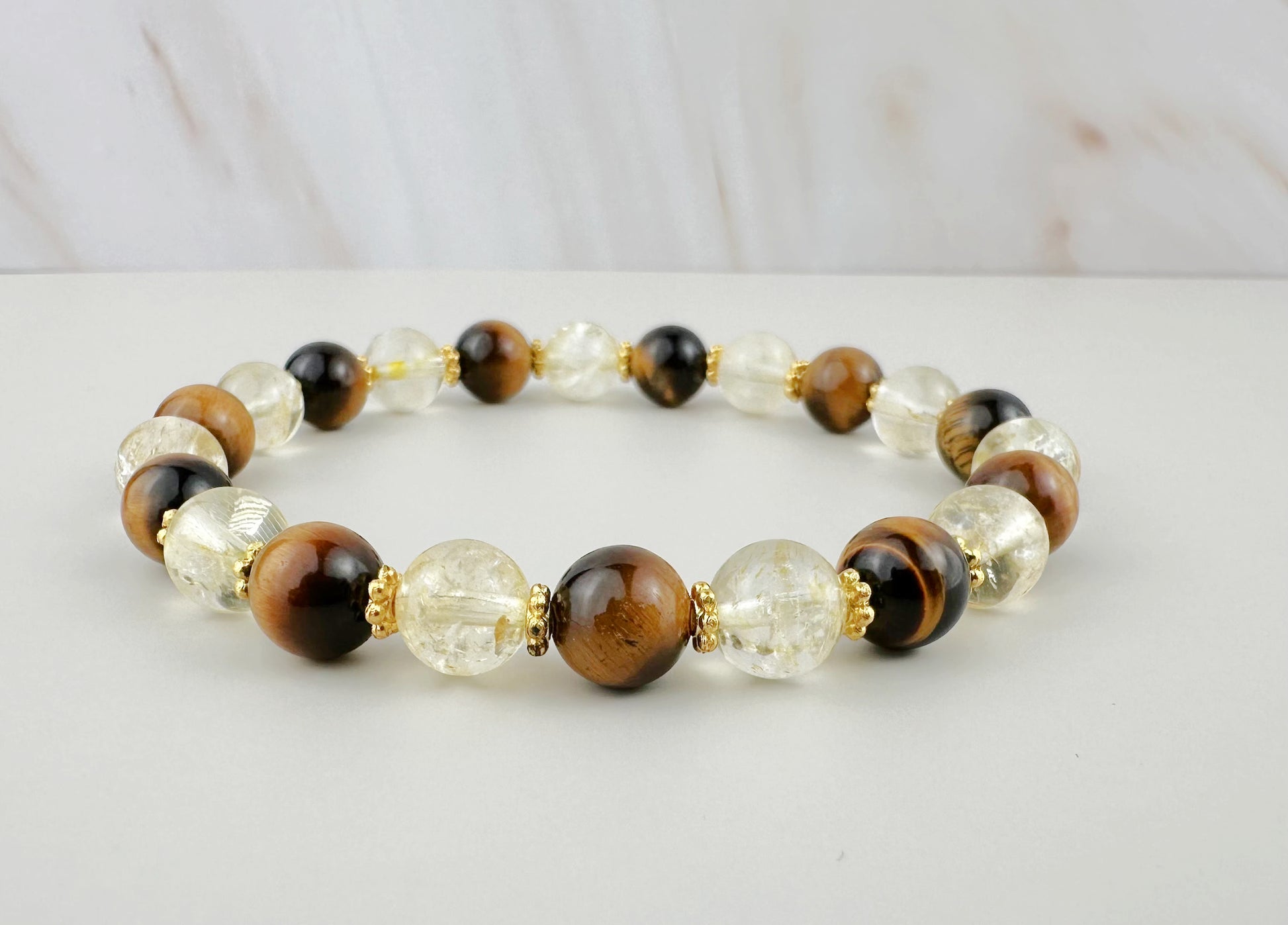 Beaded bracelet with brown, gold, and clear beads on a light background