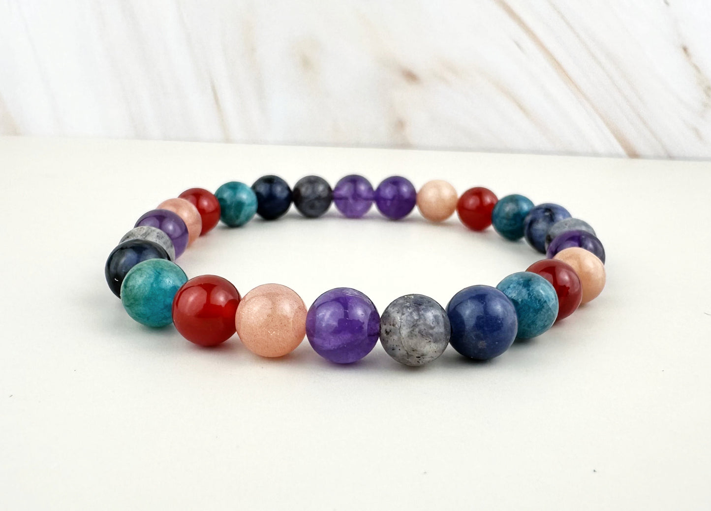 Multicolored beaded bracelet on a white surface with a blurred background