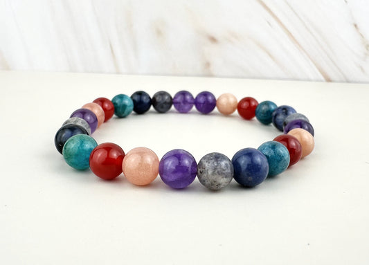 Multicolored beaded bracelet on a white surface with a blurred background