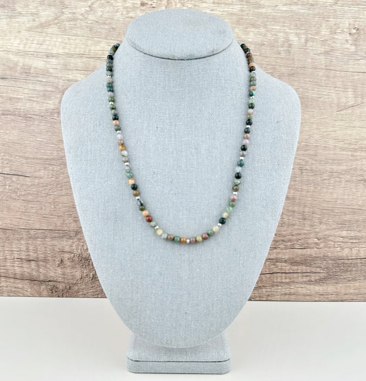 Necklace on a gray bust against a wooden background