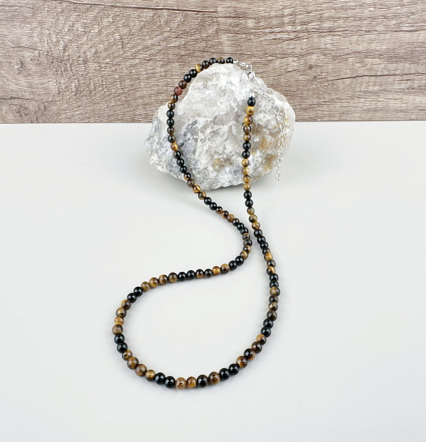 Beaded necklace on a white surface with a stone background
