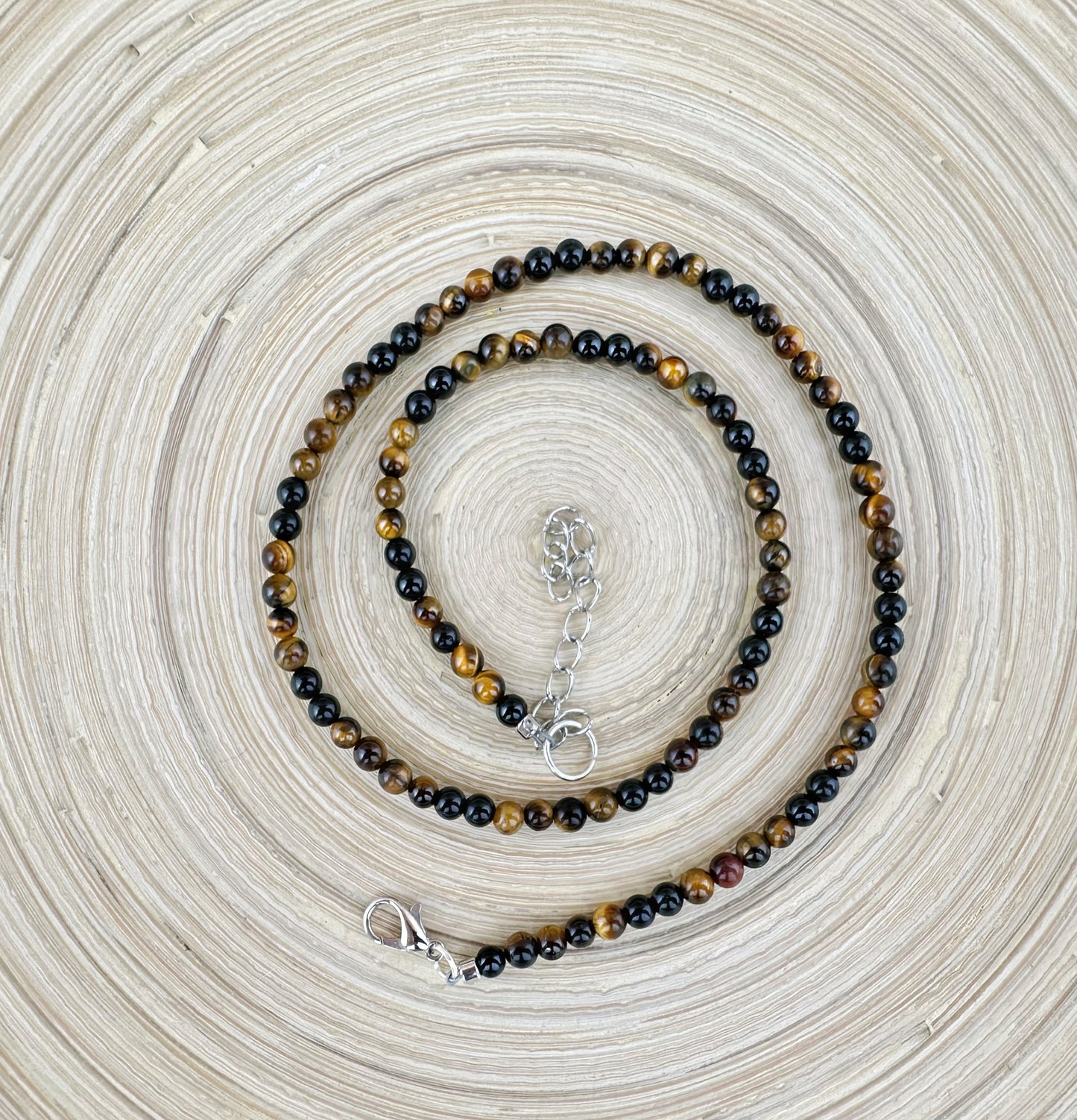 Beaded necklace with a clasp on a textured beige background